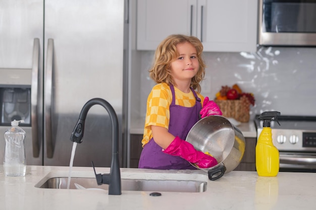Kind dat huishoudelijk werk doet Leuk kind dat helpt met het huishouden afwassen van afwas in de keuken Liefdevolle kleine helper kind dat huishouden doet Leuke kleine jongen die de afwas veegt en schoonmaakt in de Keuken