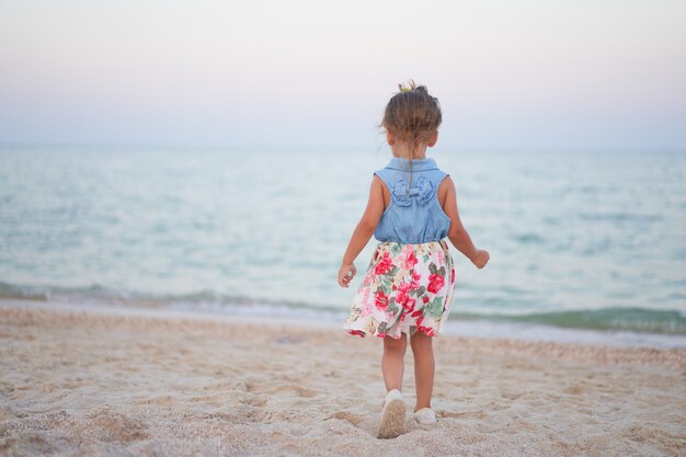 Kind dat op zand op strand loopt