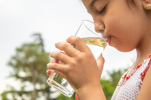 Kind dat zuiver water drinkt in de natuur.selectiv fokus