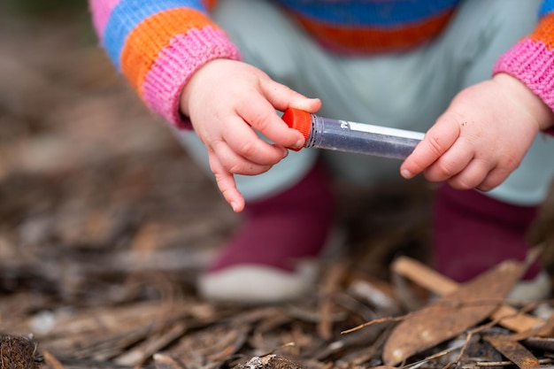 kind doet wetenschap peuter met reageerbuisjes buiten in de natuur in de bush