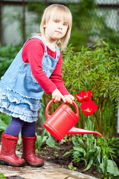 Kind drenken tulp in de tuin