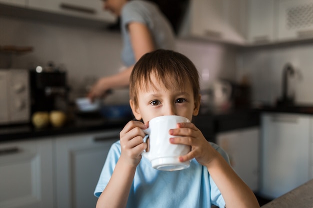 Kind drinkt thee uit mok. ontbijt