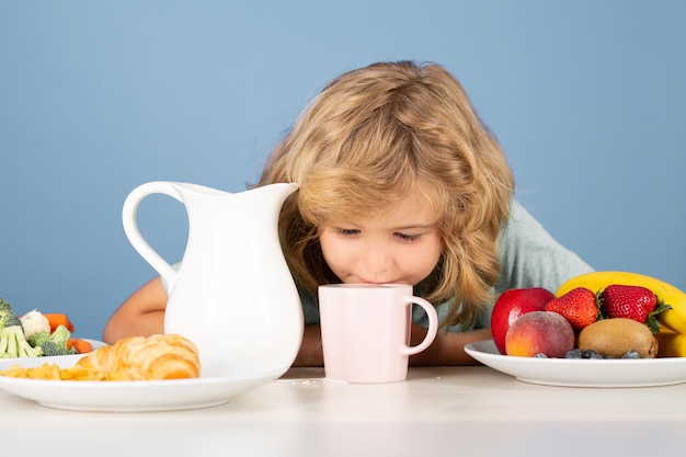 Kind drinkt zuivelmelk jongen jongen die hele koeienmelk giet portret van kind eet vers, gezond voedsel in s