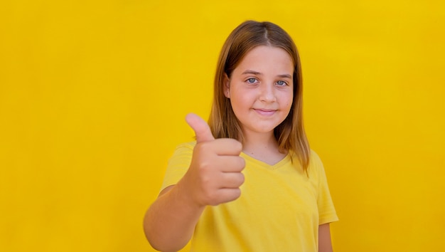 Kind duimen opdagen op gele achtergrond