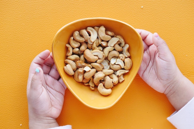 Kind eet cashewnoten op tafel
