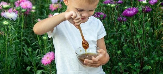 Kind eet honing in de tuin.