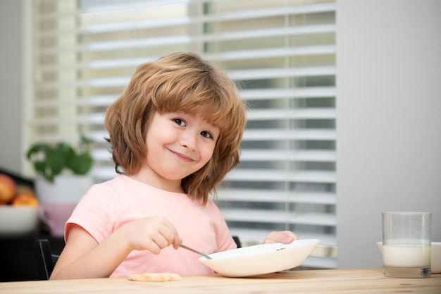 Kind eet kleine gezonde hongerige jongen die soep met lepel eet