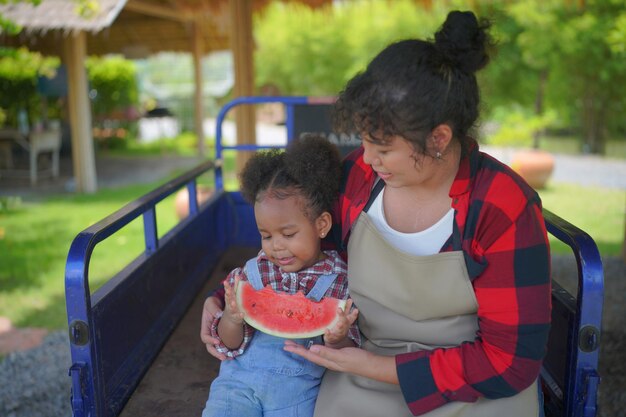 Kind eet watermeloen in de tuin Kinderen eten buiten fruit Gezonde snack voor kinderen Klein meisje speelt in de tuin hold