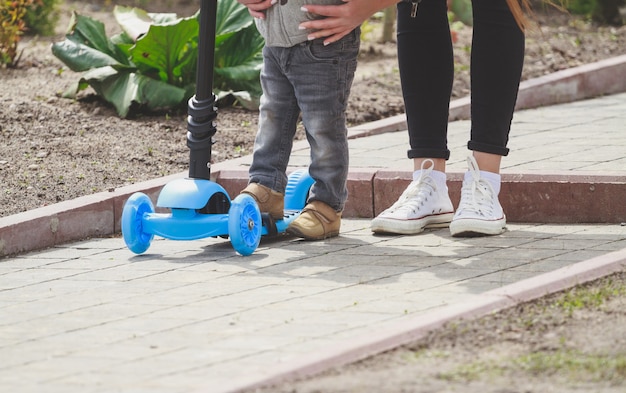 Kind en moeder spelen buiten met scooters.