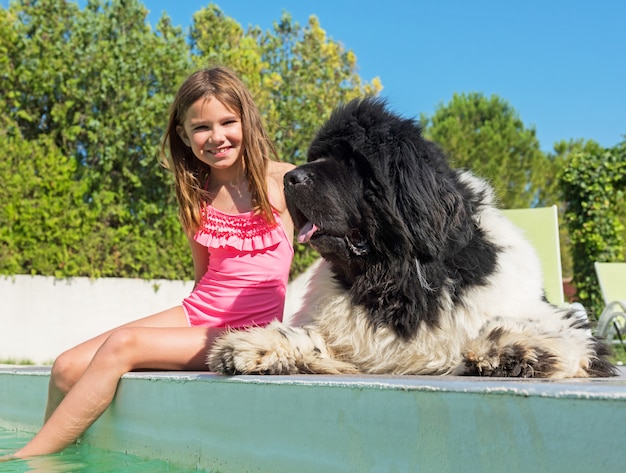 kind en Newfoundland hond in zwembad