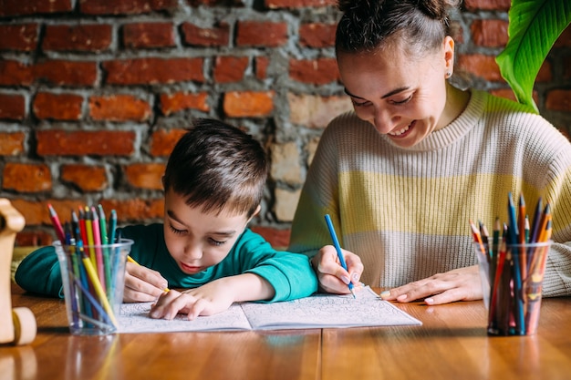 Kind en volwassene tekenen een kleurboek