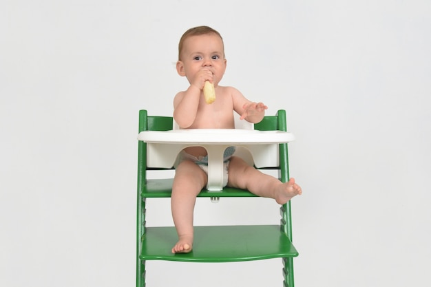 Kind eten en zitten in een kinderstoel op witte achtergrond