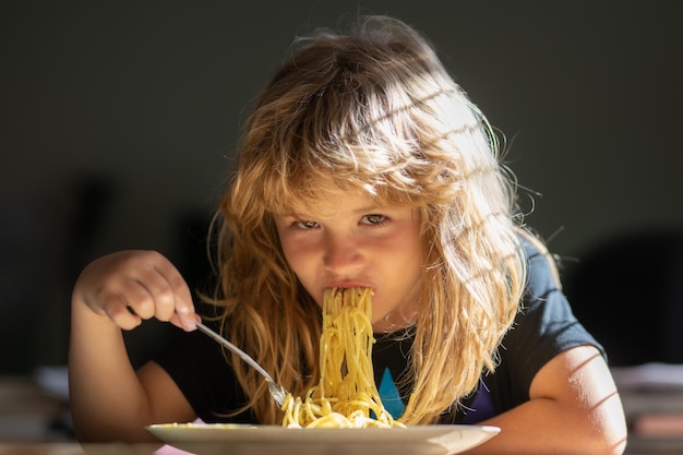 Kind eten op onscherpe achtergrond Hongerige jongetje eten Thuis eten voor kinderen Lekker eten rommelig kind spaghetti eten