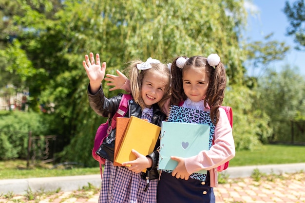 Kind gaat naar school Twee meisjes houden boeken en appels vast op de eerste schooldag