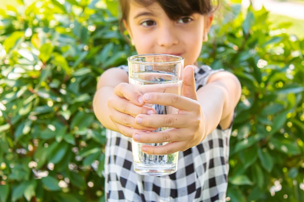 Kind glas water. selectieve aandacht. Kinderen natuur