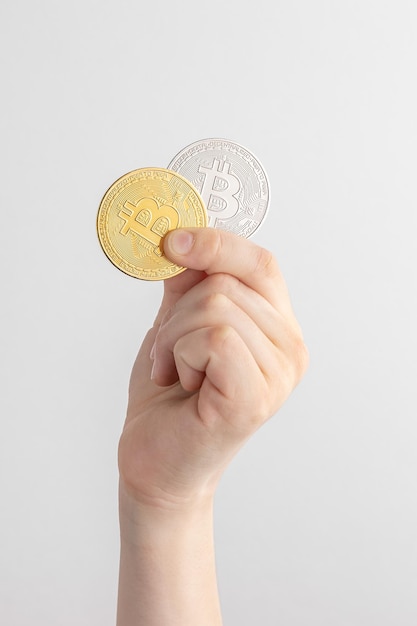 Foto kind hand met gouden en zilveren bitcoin munt cryptocurrency bedrijfsconcept