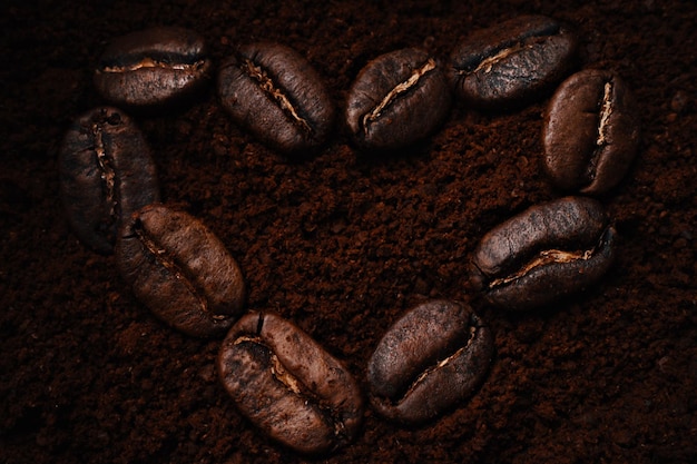 Kind of heartshaped coffee beans lie on ground coffee View from above Flat lay Love for coffee drink