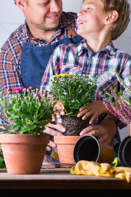 Foto kind helpt vader bij het planten van bloemen familietijd thuis