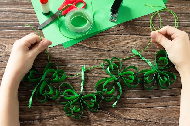 Kind houdt Garland St Patricks Day klaver ambacht van papier Handgemaakt kinderkunstproject