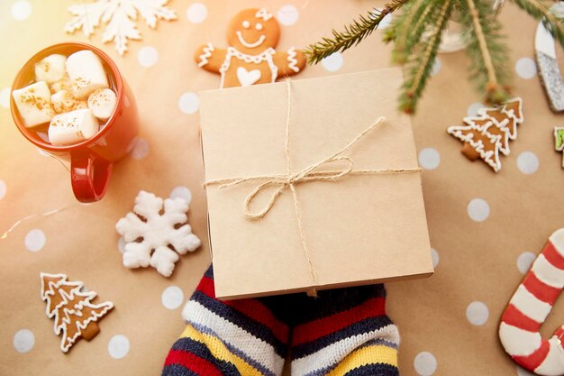 Kind houdt geschenkdoos Knutselen decoratie peperkoek koekjes tak van dennenboom warme drank