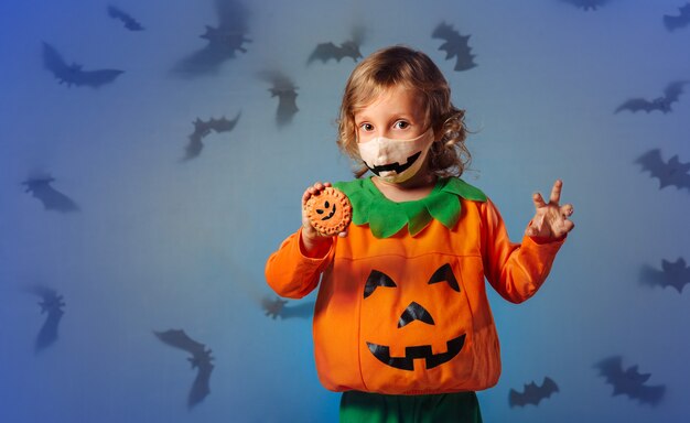 Kind in carnavalskostuum speelt met koekjes en op halloweenfeest