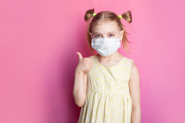 Foto kind in een medische masker op een roze muur