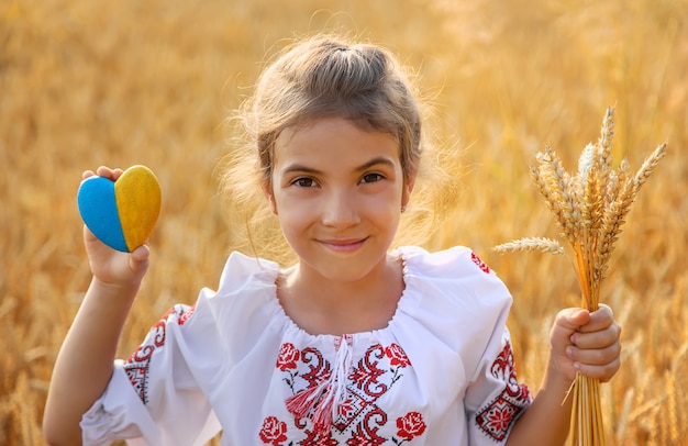 Kind in een tarweveld. In vyshyvanka, het concept van de Onafhankelijkheidsdag van Oekraïne. Selectieve aandacht.