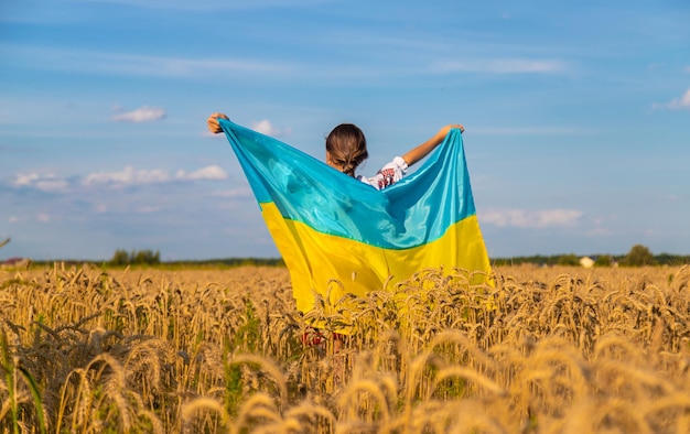 Kind in een tarweveld met de vlag van Oekraïne Selectieve aandacht Kid