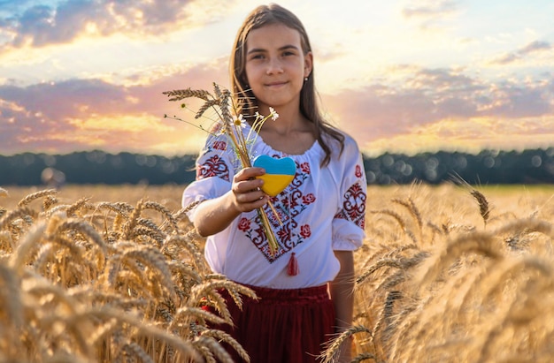 Foto kind in een tarweveld met de vlag van oekraïne selectieve aandacht natuur