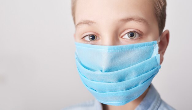 Kind in medische masker. Coronavirus en luchtverontreiniging pm2.5 concept.