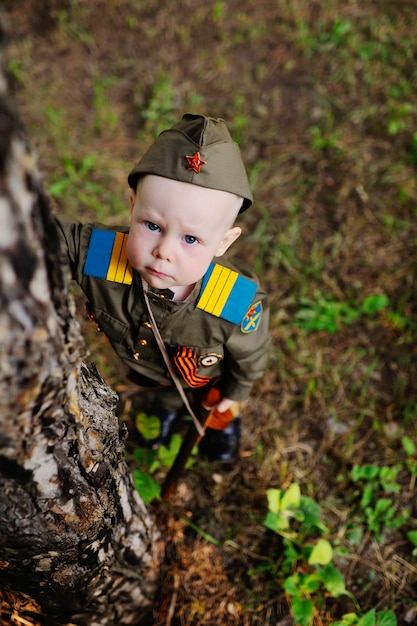 Kind in militair uniform in de natuur