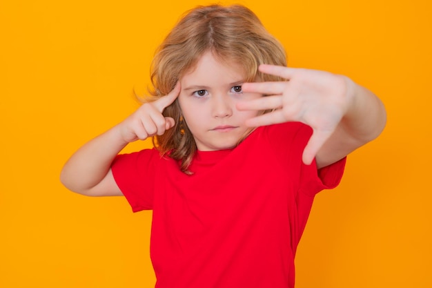 Kind in rode t-shirt die stopgebaar maakt op geïsoleerde studioachtergrond jong geitje dat waarschuwingssymbool han toont