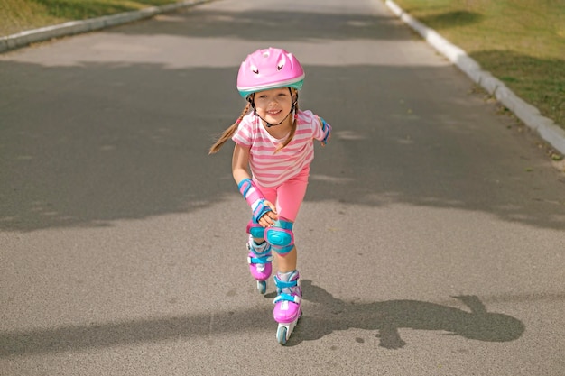 Foto kind in sportkleding haast zich langs een baan op rolschaatsen met snelheid in beweging