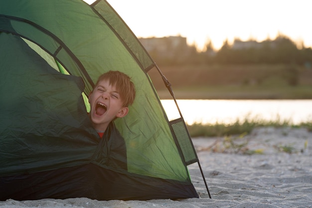 Kind in tent gaapt 's morgens vroeg op de camping Camping