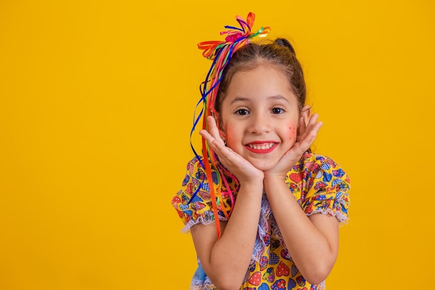 Kind in typische kleding van het beroemde Braziliaanse feest genaamd Festa Junina ter viering van Sao Joao Mooi meisje op gele achtergrondxA