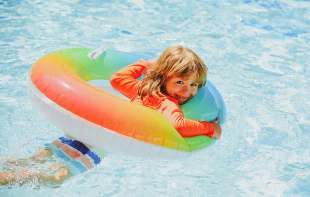 Kind in zomerbad Zomer kindervakantie Zomer kinderweekend Jongen in zwembad Jongen in aquapark op opblaasbare rubberen cirkel