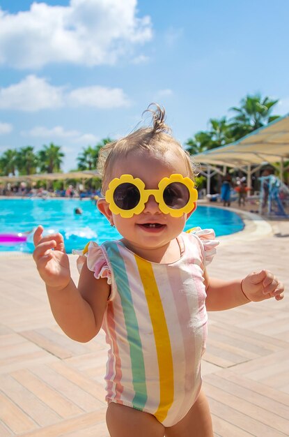 Kind in zonnebril bij het zwembad. Selectieve aandacht. Reis.
