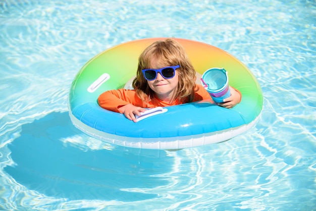 Kind in zwembad op opblaasbare ring jongetje leert zwemmen met drijvend waterspeelgoed voor peuters...