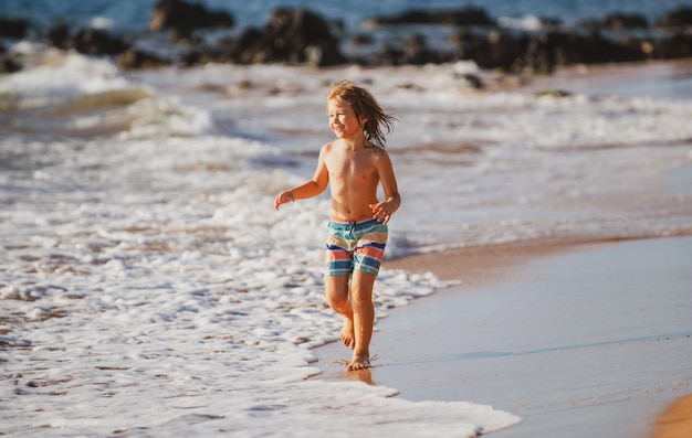 Kind jongen aan de kust Klein kind speelt in de oceaan Vakantie aan zee Het kind in golven