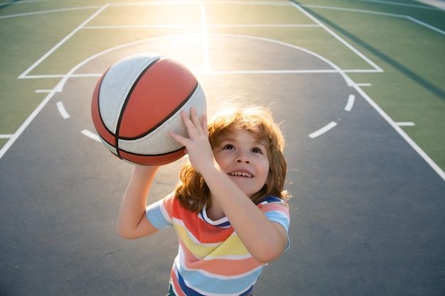 Kind jongen bereidt zich voor op basketbal schieten Portret van sportieve kinderen