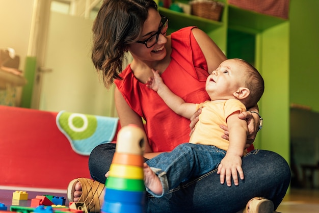 Kind jongen en moeder spelen met educatief speelgoed.