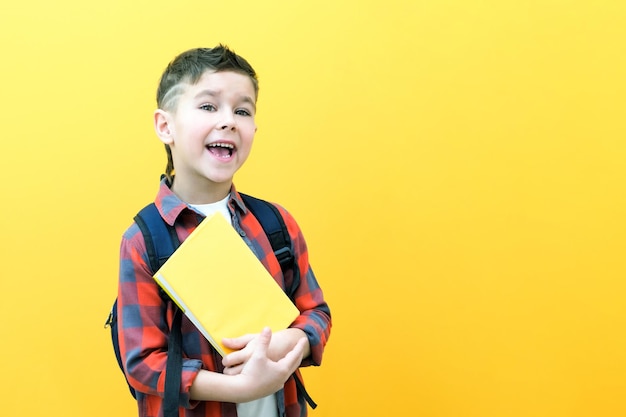 Kind jongen in glazen geïsoleerd op gele papieren muur Geweldig idee Gelukkig lachend schooljongen gaat terug naar school Succes motivatie winnaar genie concept