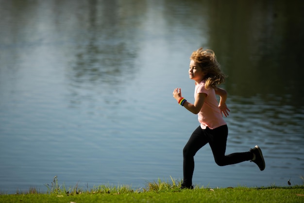 Kind jongen joggen in park buiten Kinderen sport gelukkige actieve kinderen joggen buiten hardlopen in lente park