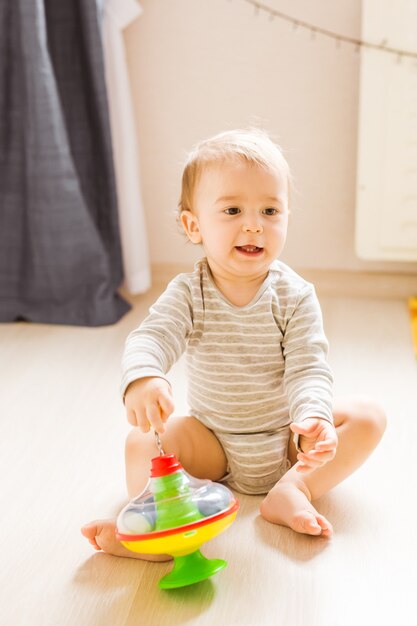 Kind jongen peuter spelen met speelgoed binnenshuis.