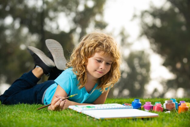 Kind jongen tekenen in de zomer park schilderen kunst kleine kunstenaar schilder tekenen foto's buiten kinderen h