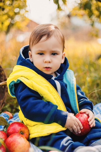 Kind jongen zit in de tuin van de appelteelt weinig levensstijljong geitje in tuinierende boerderij