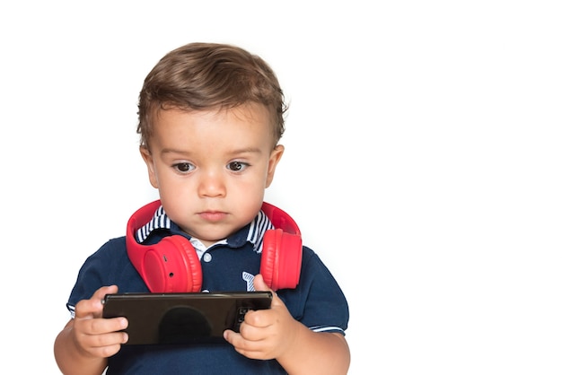 Kind kijken naar video's op mobiele telefoon met rode koptelefoon en donkerblauw shirt