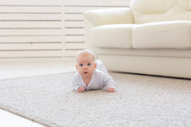 Kind-, kinder- en babyconcept - mooie baby ligt op de vloer.