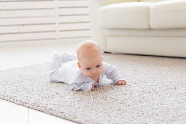 Kind-, kinder- en babyconcept - mooie baby ligt op de vloer.