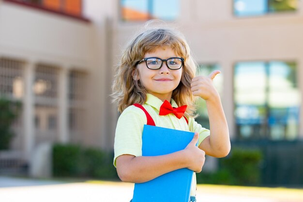 Kind klaar om naar school te gaan schooljongen leerling met rugzak buiten